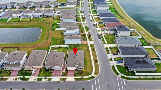 drone / aerial view with a water view and a residential view