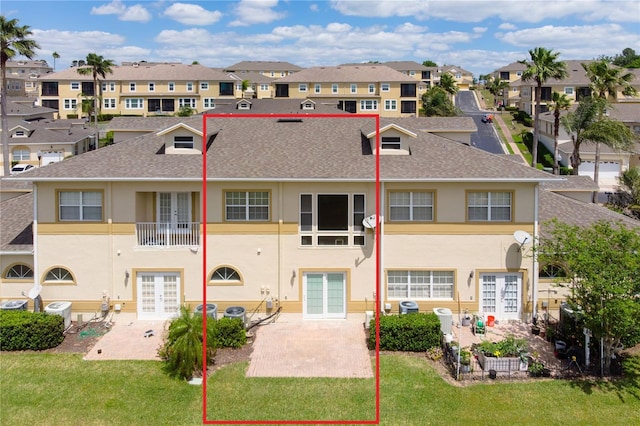 13221 Fountainbleau Dr, Clermont, FL 34711 - back of property featuring french doors, a residential view, stucco siding, a yard, and roof with shingles
