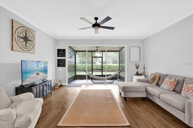 living area featuring crown molding, a sunroom, dark wood finished floors, and ceiling fan