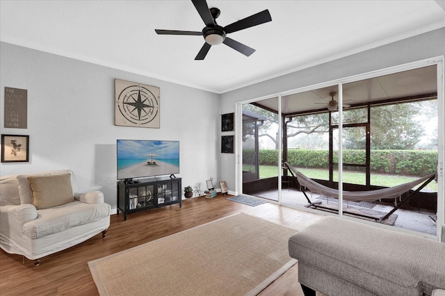 living area with crown molding, baseboards, ceiling fan, and wood finished floors