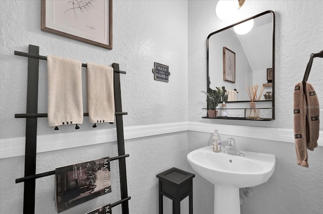 bathroom featuring a textured wall and a sink