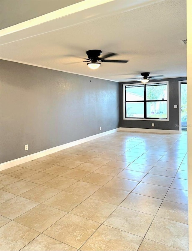 spare room with ceiling fan, light tile patterned flooring, visible vents, and baseboards