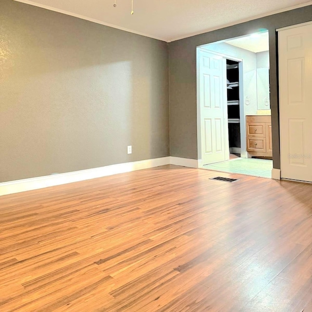 unfurnished bedroom featuring light wood-style flooring, visible vents, and baseboards