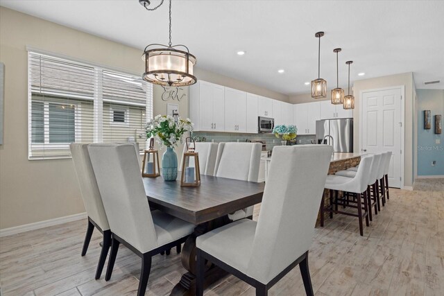 dining room featuring a notable chandelier, recessed lighting, visible vents, light wood-type flooring, and baseboards