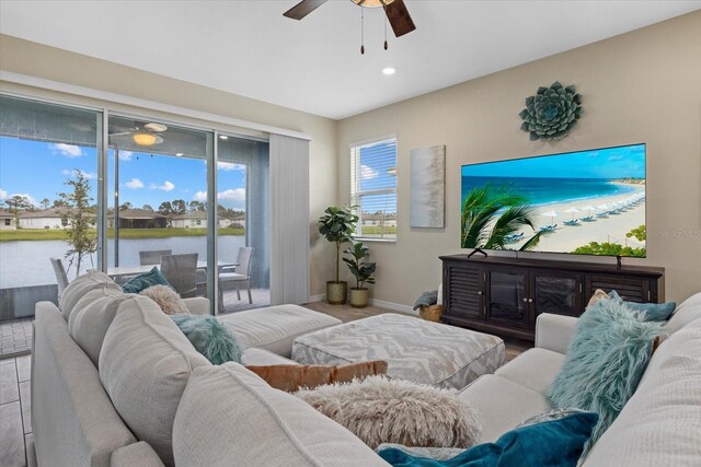 living area featuring baseboards and a ceiling fan