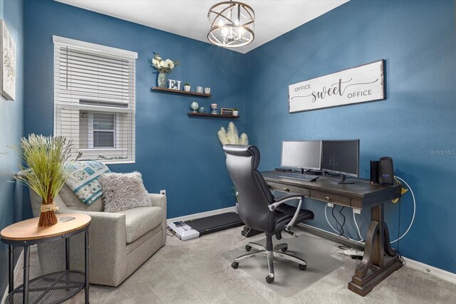 carpeted office space featuring a notable chandelier and baseboards