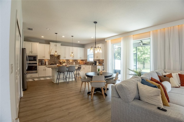 14664 Spotted Sandpiper Blvd, Winter Garden, FL 34787 - dining space featuring light wood-style flooring, a chandelier, and recessed lighting