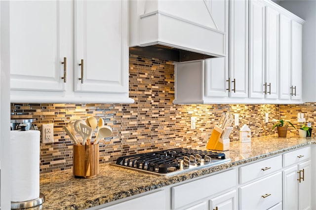 14664 Spotted Sandpiper Blvd, Winter Garden, FL 34787 - kitchen with stainless steel gas stovetop, custom exhaust hood, white cabinets, and backsplash