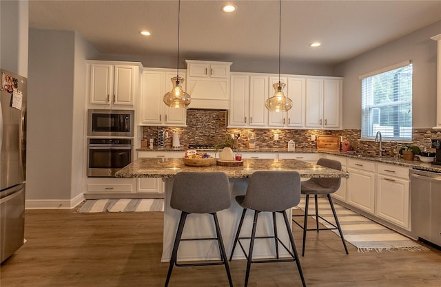 14664 Spotted Sandpiper Blvd, Winter Garden, FL 34787 - kitchen featuring appliances with stainless steel finishes, white cabinets, a kitchen breakfast bar, and recessed lighting