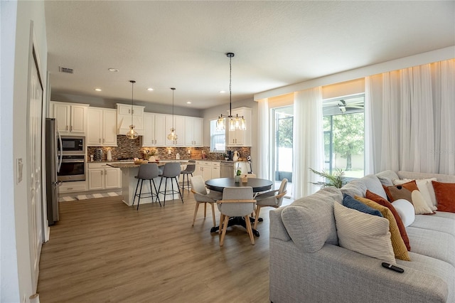 14664 Spotted Sandpiper Blvd, Winter Garden, FL 34787 - living room with plenty of natural light, light wood-style flooring, a chandelier, and recessed lighting
