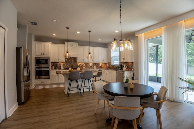 14664 Spotted Sandpiper Blvd, Winter Garden, FL 34787 - dining space with plenty of natural light, wood finished floors, recessed lighting, and a chandelier