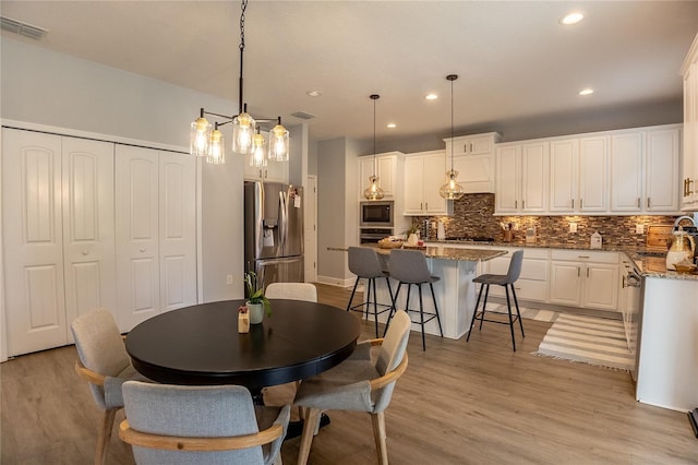 14664 Spotted Sandpiper Blvd, Winter Garden, FL 34787 - dining room with light wood-style floors and recessed lighting