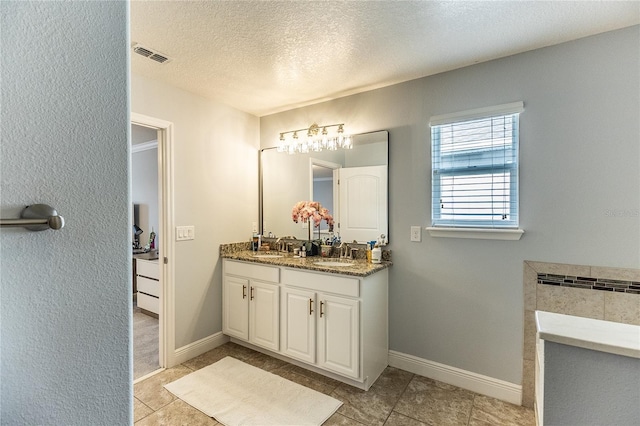 14664 Spotted Sandpiper Blvd, Winter Garden, FL 34787 - bathroom with double vanity, a textured ceiling, and tile patterned flooring
