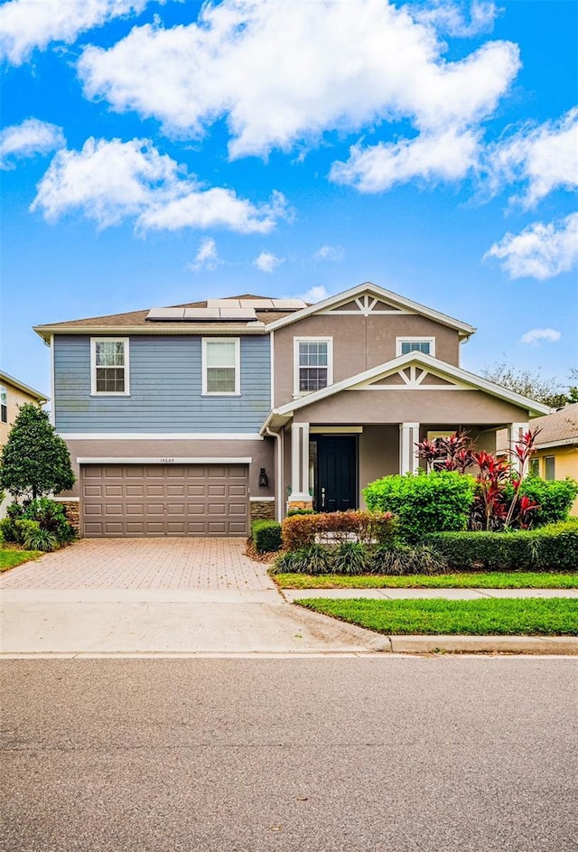 14664 Spotted Sandpiper Blvd, Winter Garden, FL 34787 - view of front of house featuring an attached garage, decorative driveway, solar panels, and stucco siding
