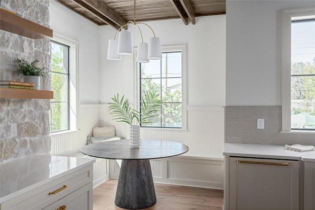 dining space with breakfast area, wainscoting, beam ceiling, and light wood-style floors