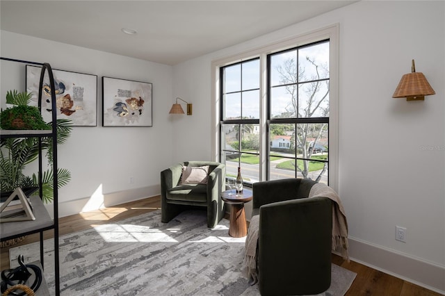 living area featuring baseboards and wood finished floors