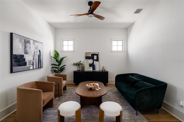 sitting room featuring dark wood-style floors, baseboards, visible vents, and a healthy amount of sunlight