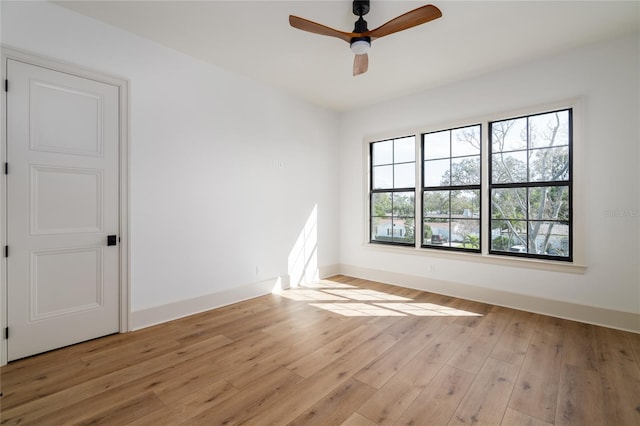 empty room featuring light wood-style flooring, baseboards, and ceiling fan