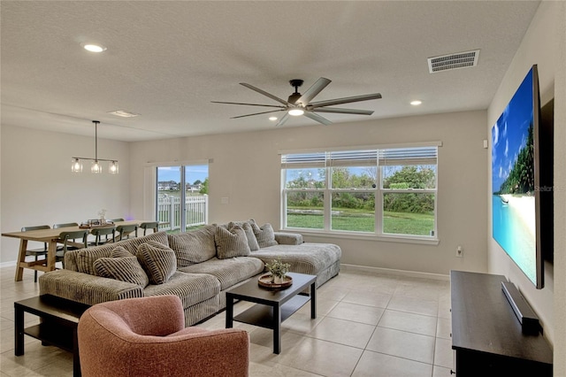 living room with light tile patterned floors, baseboards, visible vents, a textured ceiling, and recessed lighting