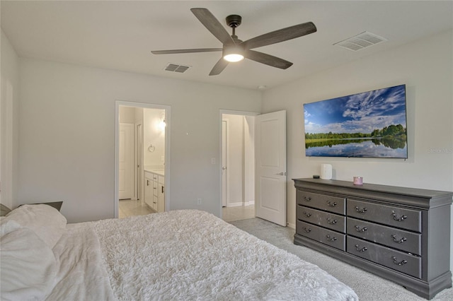 bedroom with ensuite bath, visible vents, and a ceiling fan