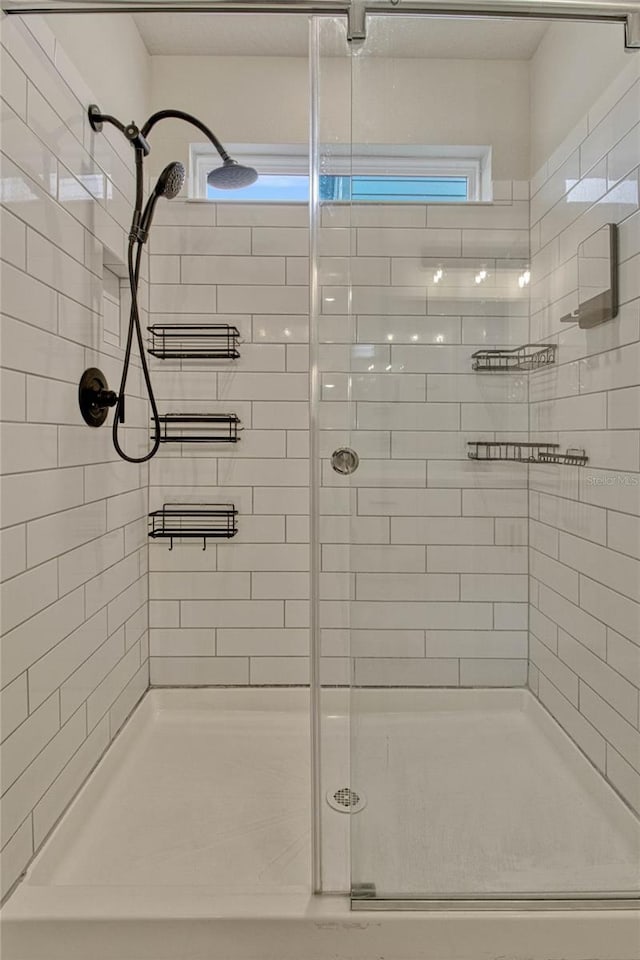 full bathroom featuring a shower stall and a wealth of natural light