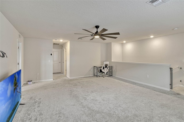 carpeted empty room featuring baseboards, visible vents, ceiling fan, and a textured ceiling