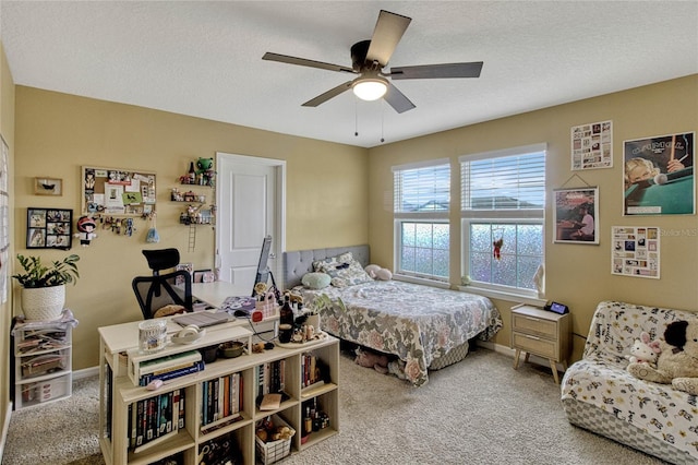 carpeted bedroom with a textured ceiling, ceiling fan, and baseboards