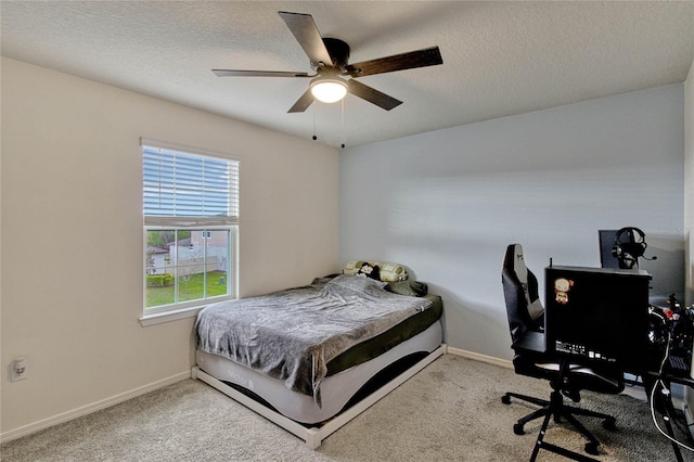 carpeted bedroom featuring ceiling fan, a textured ceiling, and baseboards