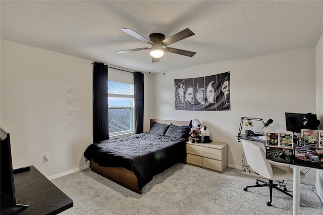 carpeted bedroom with ceiling fan, baseboards, and a textured ceiling