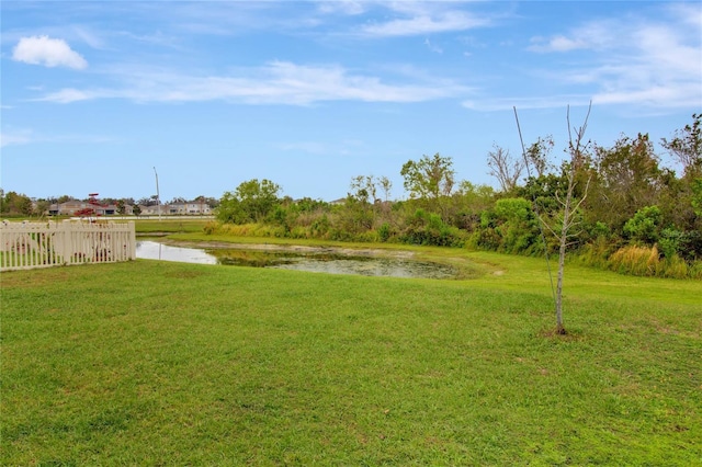 view of yard featuring a water view and fence