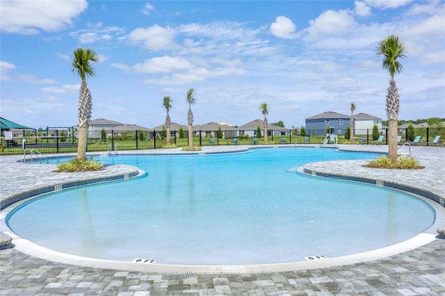 community pool featuring a residential view and fence