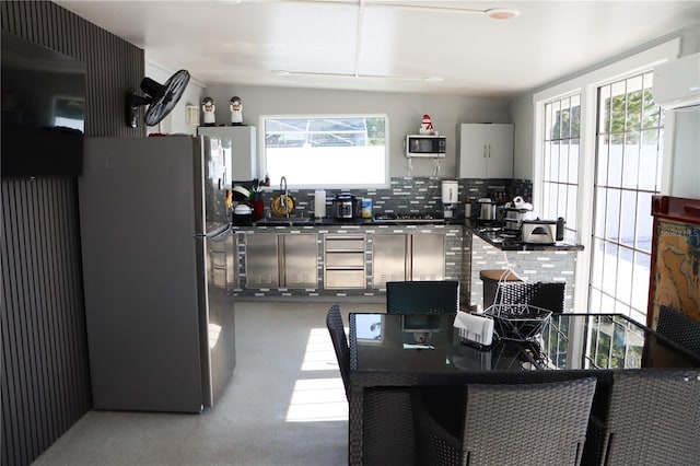 kitchen with dark countertops, tasteful backsplash, appliances with stainless steel finishes, and a wall mounted air conditioner