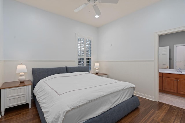 bedroom featuring a sink, wood finished floors, a ceiling fan, and ensuite bathroom