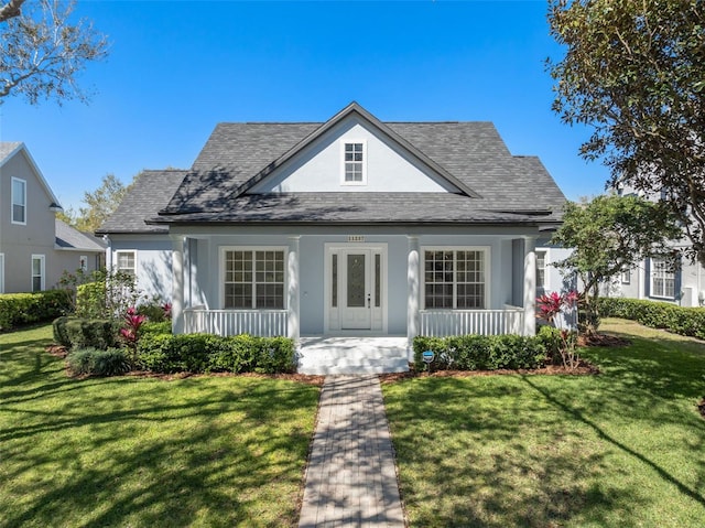 bungalow with covered porch, a front lawn, and stucco siding