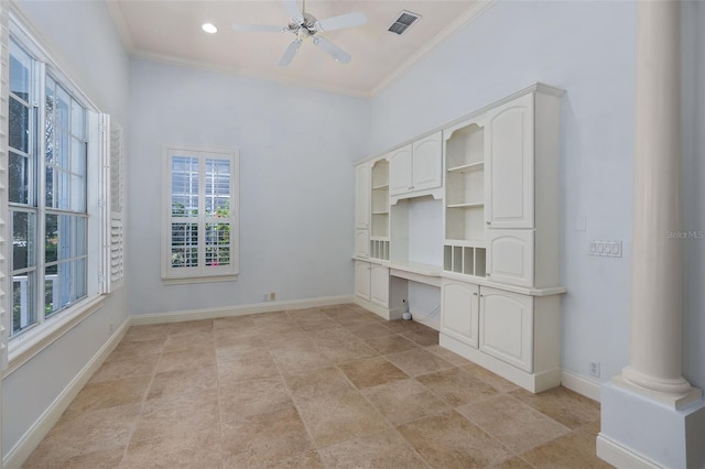 unfurnished office with baseboards, built in desk, visible vents, and crown molding