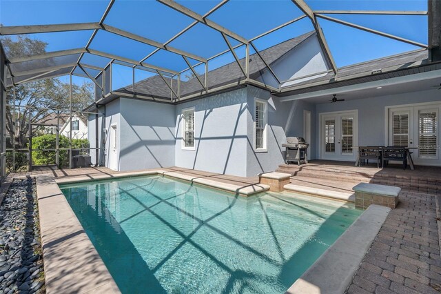 outdoor pool with ceiling fan, a patio, a lanai, french doors, and grilling area