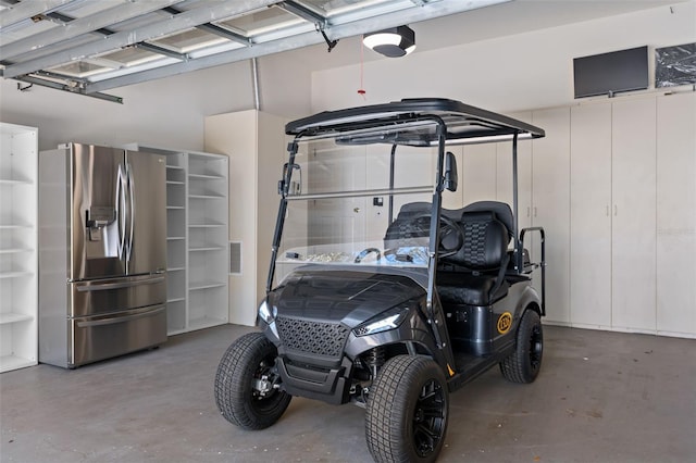 garage featuring stainless steel fridge and a garage door opener