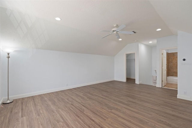 bonus room with a ceiling fan, vaulted ceiling, baseboards, and wood finished floors