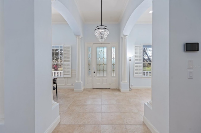 entryway with baseboards, crown molding, ornate columns, and tile patterned floors