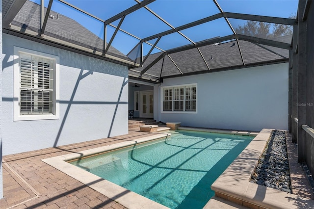 pool featuring glass enclosure, a ceiling fan, a patio, and french doors