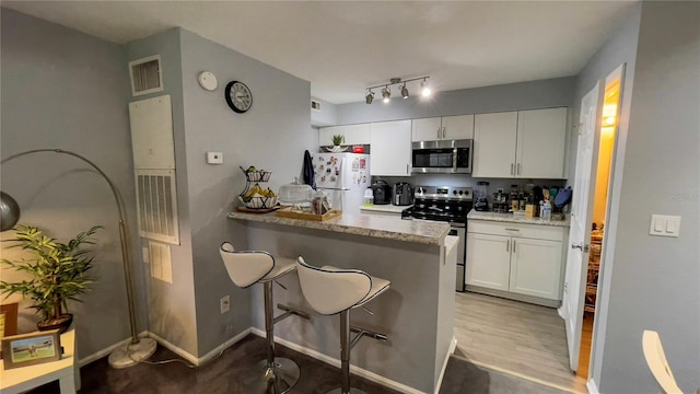 2200 Metropolitan Way Unit 926, Orlando, FL 32839 - kitchen featuring stainless steel appliances, a peninsula, white cabinets, and a kitchen bar