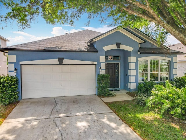 ranch-style home featuring stucco siding, a garage, roof with shingles, and concrete driveway