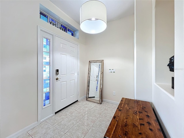 foyer featuring baseboards and light tile patterned flooring