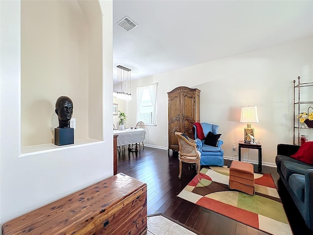 living area featuring dark wood-style floors, visible vents, and baseboards