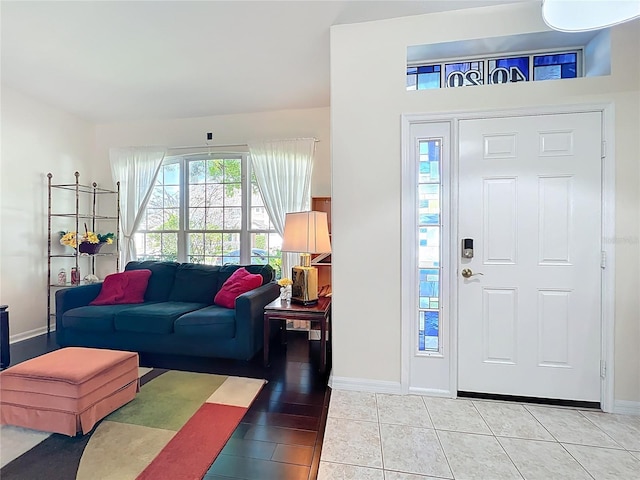 foyer entrance with light tile patterned floors and baseboards