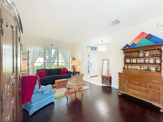 living room featuring visible vents and dark wood-style floors