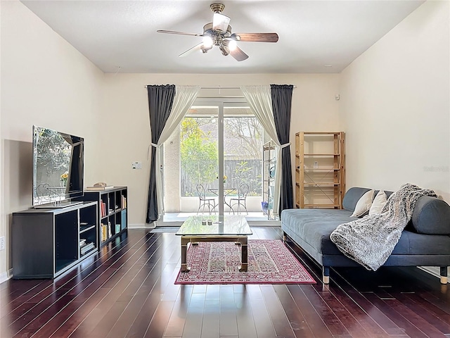 living room featuring dark wood-style floors, baseboards, and a ceiling fan