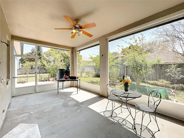 unfurnished sunroom featuring a ceiling fan