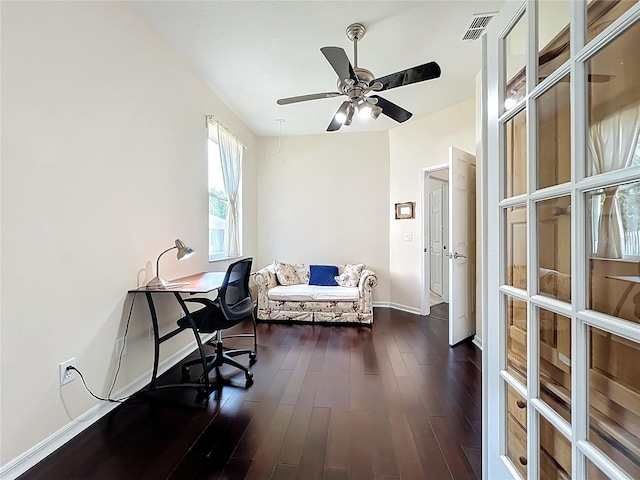 home office with dark wood finished floors, visible vents, a ceiling fan, and baseboards