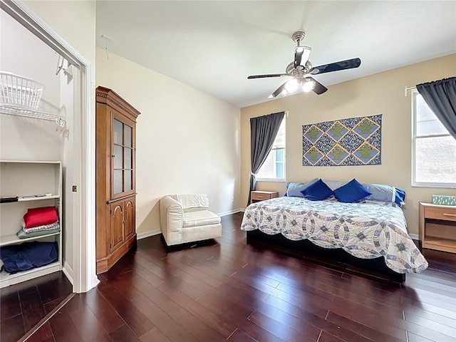 bedroom featuring dark wood-style floors, multiple windows, baseboards, and ceiling fan